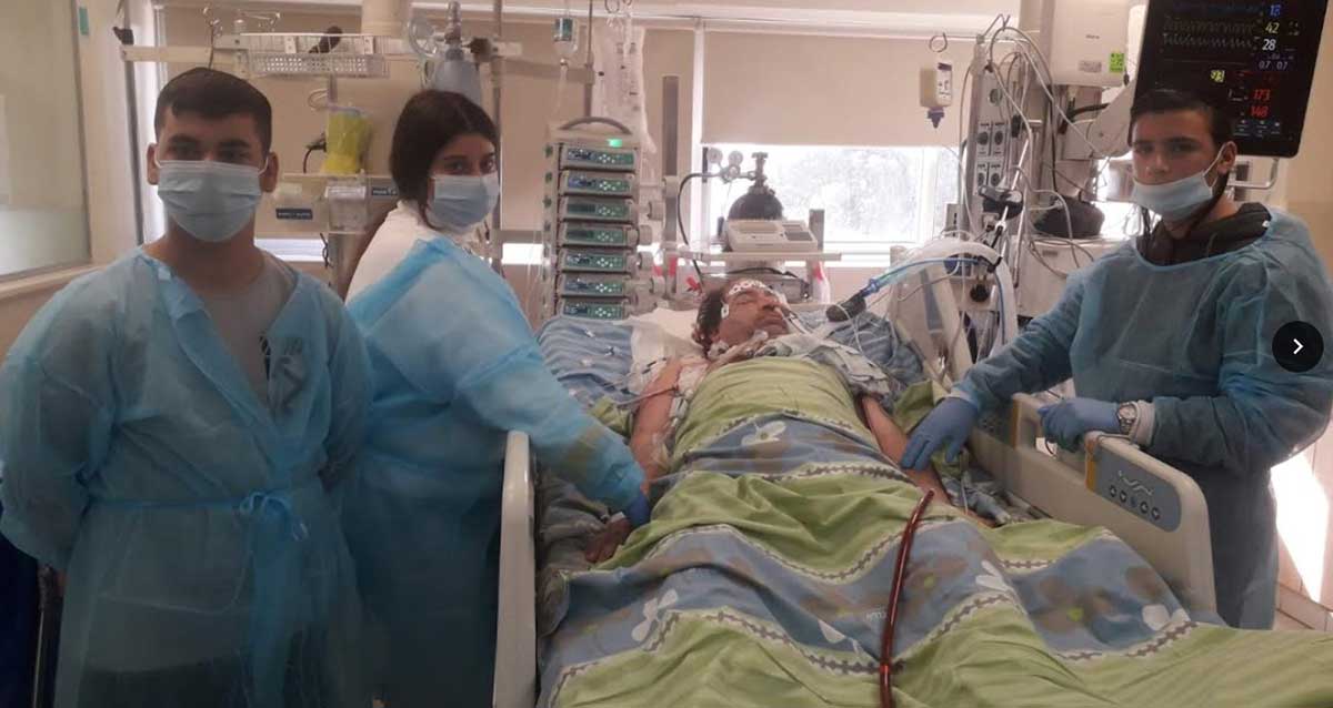 אלעד אליהו מורדם, מוקף בשלושת ילדיו. צילום: כרמל